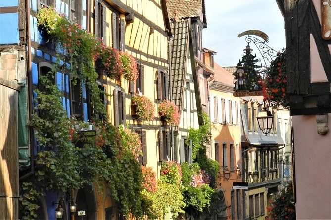 A street of half-timbered fronts hung with flower boxes and a wrought-iron sign